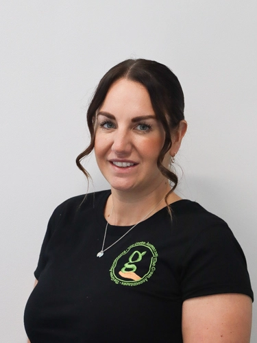Professional head-shot of a woman smiling in front of a neutral background.