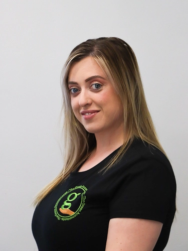 Professional headshot of a woman with long blonde hair and a nose ring, smiling slightly against a plain light background.